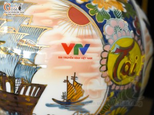 Bình hút lộc Nhị cảnh Thuận Buồm Xuôi Gió và Công Đào vẽ vàng 24k in logo VTV nền cam, cao 25cm