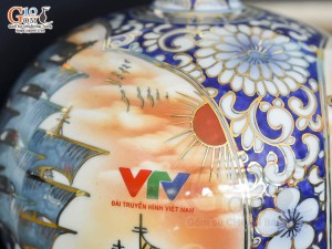 Bình hút lộc Nhị cảnh Thuận Buồm Xuôi Gió và Công Đào vẽ vàng 24k in logo VTV nền cam, cao 23cm