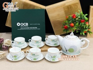 Bộ ấm chén dáng chóp lửa men trắng kẻ chỉ vàng, in logo quà tặng ngân hàng OCB