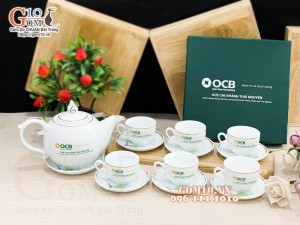 Bộ ấm chén dáng chóp lửa men trắng kẻ chỉ vàng, in logo quà tặng ngân hàng OCB