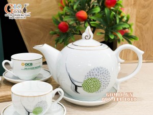 Bộ ấm chén dáng chóp lửa men trắng kẻ chỉ vàng, in logo quà tặng ngân hàng OCB