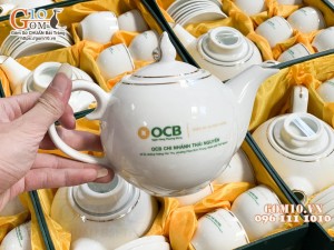 Bộ ấm chén dáng chóp lửa men trắng kẻ chỉ vàng, in logo quà tặng ngân hàng OCB