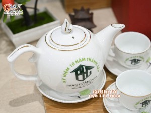 Bộ ấm chén dáng chóp lửa men trắng vẽ Bồ Công Anh chỉ vàng kim, in logo Phan Hoàng Gia