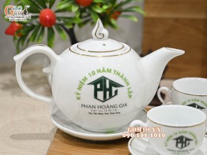 Bộ ấm chén dáng chóp lửa men trắng vẽ Bồ Công Anh chỉ vàng kim, in logo Phan Hoàng Gia