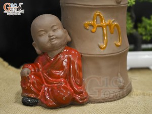 Chậu tượng trồng cây chú Tiểu áo đỏ bên gốc trúc, cao 25cm