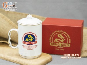 Cốc sứ dáng cao quai nắm men trắng có nắp kẻ chỉ vàng in logo Công ty Song King, 500ml