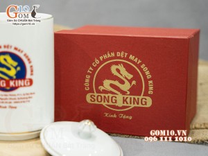 Cốc sứ dáng cao quai nắm men trắng có nắp kẻ chỉ vàng in logo Công ty Song King, 500ml