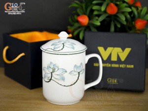 Cốc sứ có nắp men trắng vẽ sen xanh in logo VTV, đường kính 8cm