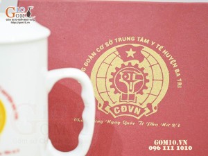 Cốc sứ dáng cao quai nắm có nắp men trắng in logo