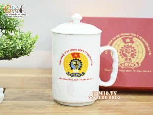 Cốc sứ dáng cao quai nắm có nắp men trắng in logo