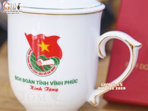 Cốc sứ dáng chóp lửa men trắng có nắp kẻ chỉ vàng kim, in logo quà tặng