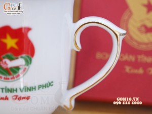 Cốc sứ dáng chóp lửa men trắng có nắp kẻ chỉ vàng kim, in logo quà tặng