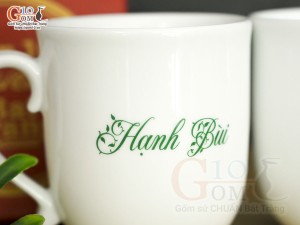 Cốc sứ dáng chóp lửa men trắng hoa mai xanh có nắp in tên, 400ml