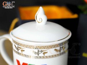 Cốc sứ dáng chóp lửa men trắng họa tiết Trống Đồng vàng kim, in logo VTV 400ml