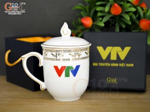 Cốc sứ dáng chóp lửa men trắng họa tiết Trống Đồng vàng kim, in logo VTV 400ml