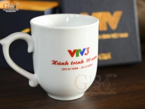 Cốc sứ dáng chóp lửa men trắng in logo Hành Trình 30 năm VTV3