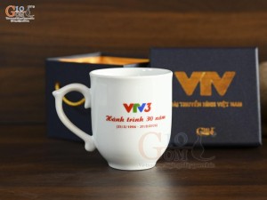 Cốc sứ dáng chóp lửa men trắng in logo Hành Trình 30 năm VTV3