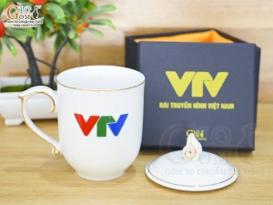 Cốc sứ dáng chóp lửa men trắng kẻ chỉ vàng kim có nắp in logo VTV, 400ml