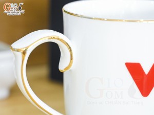 Cốc sứ dáng chóp lửa men trắng kẻ chỉ vàng kim có nắp in logo VTV, 400ml