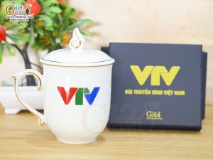 Cốc sứ dáng chóp lửa men trắng kẻ chỉ vàng kim có nắp in logo VTV, 400ml