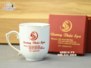 Cốc sứ dáng chóp lửa men trắng kẻ chỉ vàng kim, in logo quà tặng 400ml