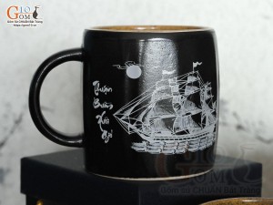 Cốc sứ dáng lục giác quai tròn màu đen cảnh Thuận Buồm Xuôi Gió, in logo VTV