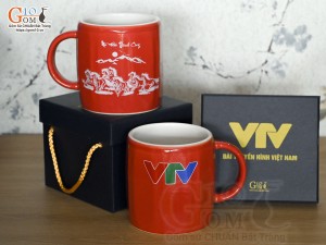 Cốc sứ dáng lục giác quai tròn màu đỏ cảnh Mã Đáo Thành Công, in logo VTV