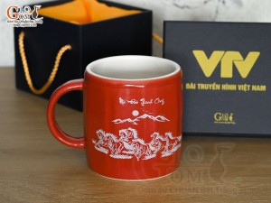 Cốc sứ dáng lục giác quai tròn màu đỏ cảnh Mã Đáo Thành Công, in logo VTV