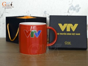 Cốc sứ dáng lục giác quai tròn màu đỏ cảnh Mã Đáo Thành Công, in logo VTV