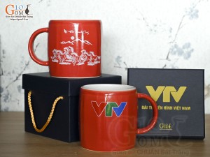 Cốc sứ dáng lục giác quai tròn màu đỏ cảnh Mã Đáo Thành Công, in logo VTV
