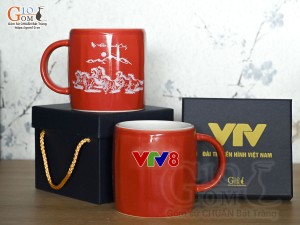 Cốc sứ dáng lục giác quai tròn màu đỏ cảnh Mã Đáo Thành Công, in logo VTV8