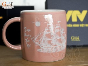 Cốc sứ dáng lục giác quai tròn màu hồng cảnh Thuận Buồm Xuôi Gió, in logo VTV