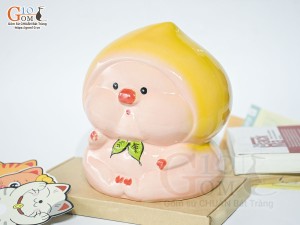 Tượng sứ tiết kiệm dáng trái đào màu vàng, cao 20cm